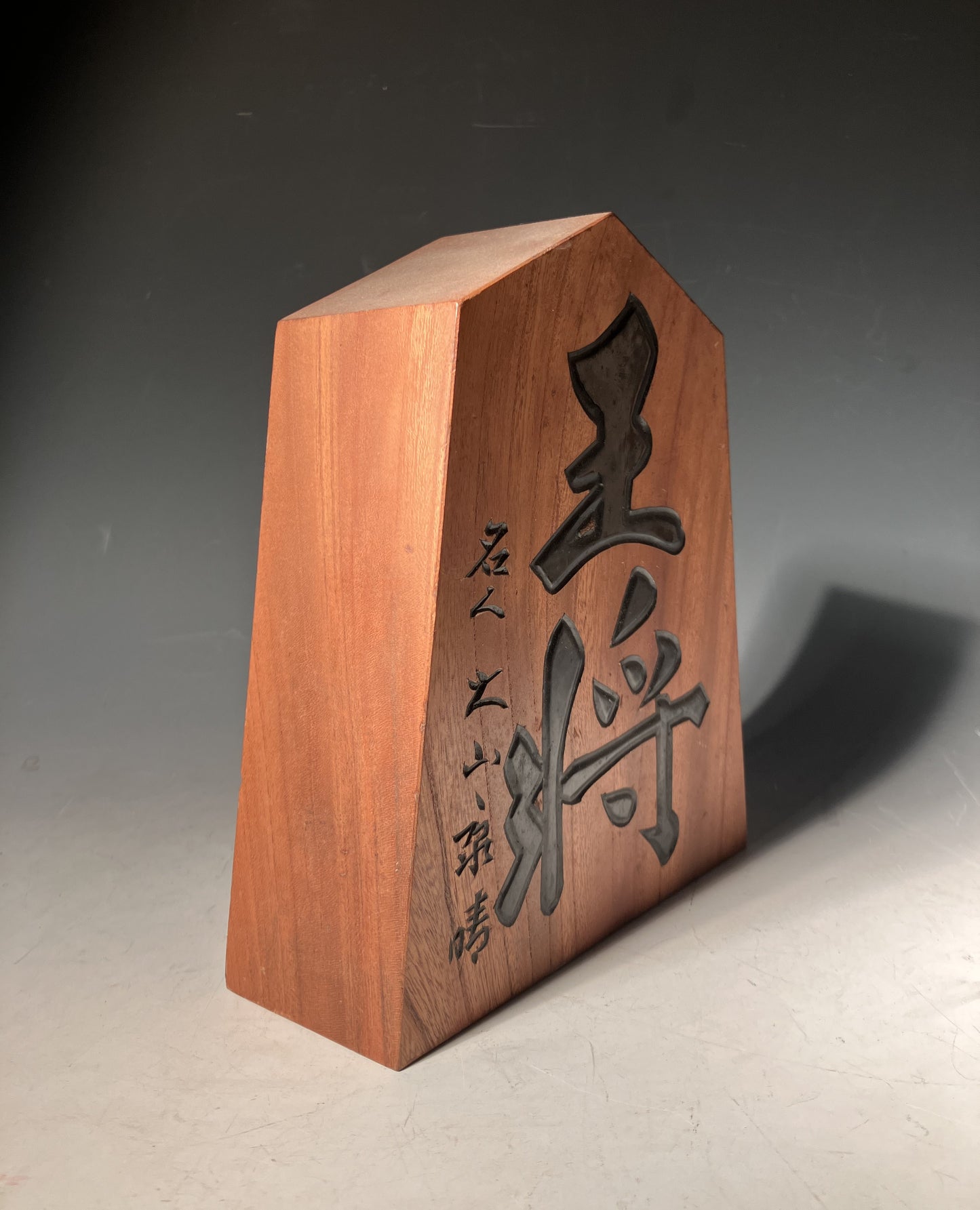 Wooden block with engraved characters on a gray background