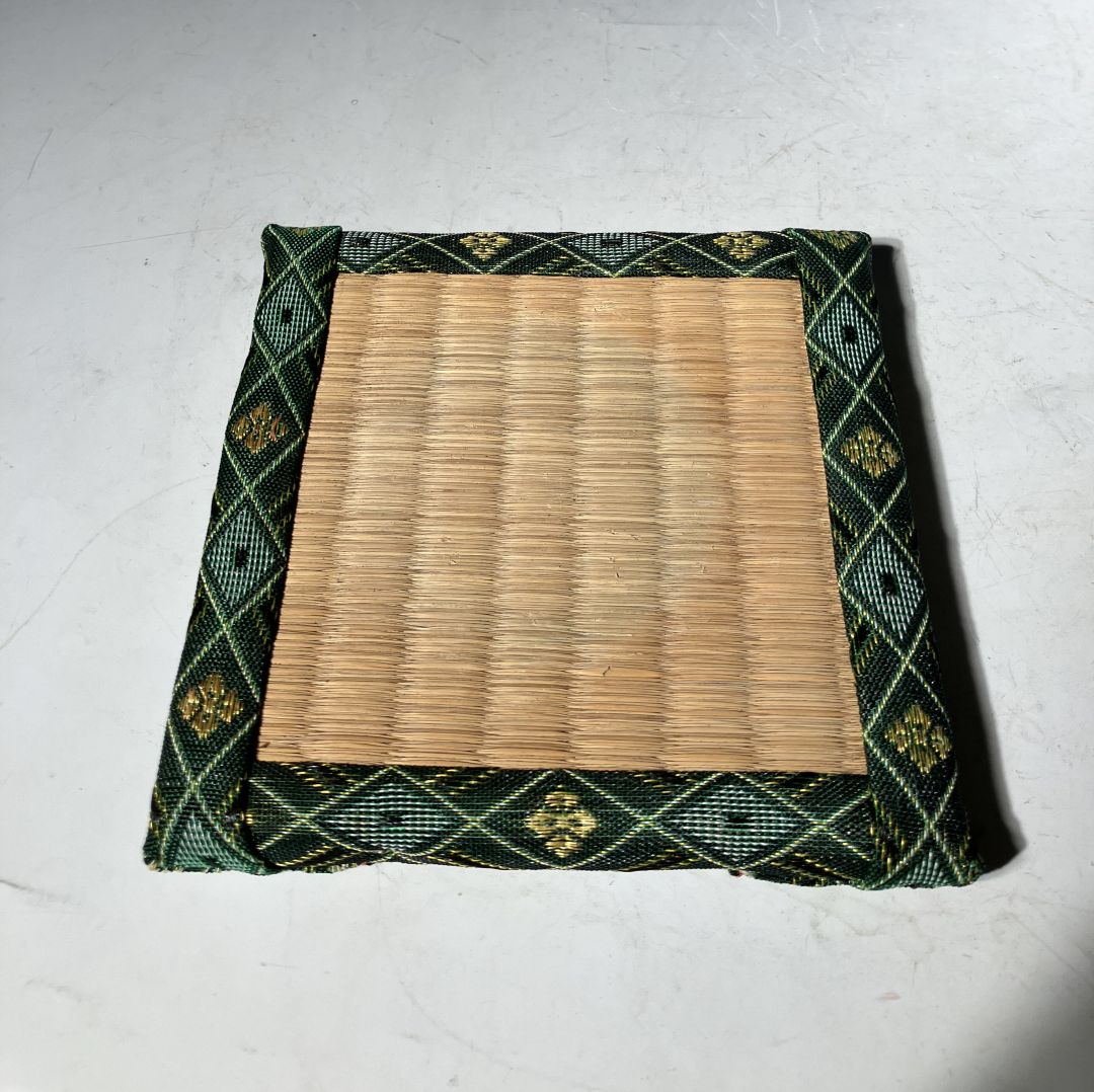 Bamboo mat with green patterned border on a white background