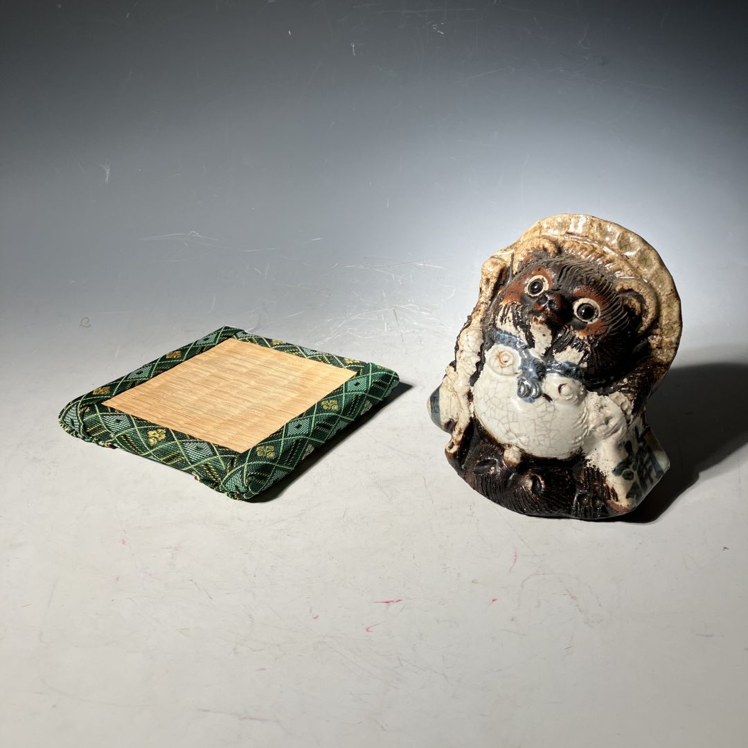 Small figurine of a creature with a bow tie on a gray surface