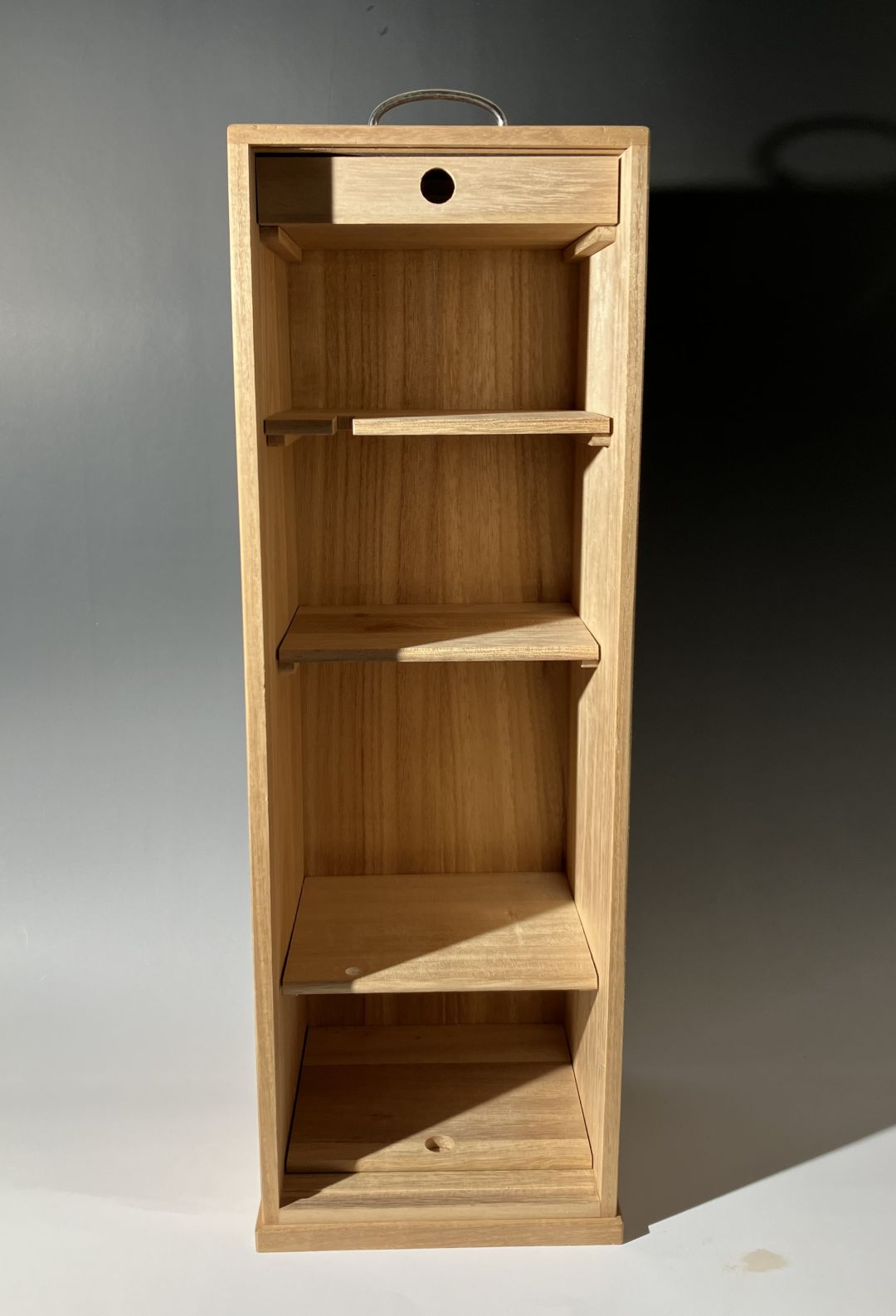 Wooden corner shelf unit with multiple shelves on a neutral background
