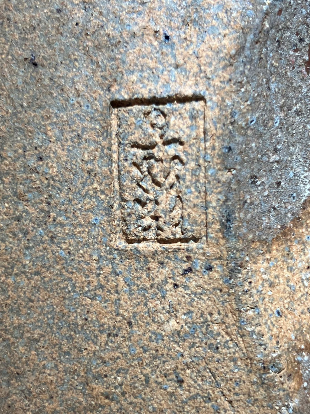 Brick stamp with a rectangular design on a concrete surface