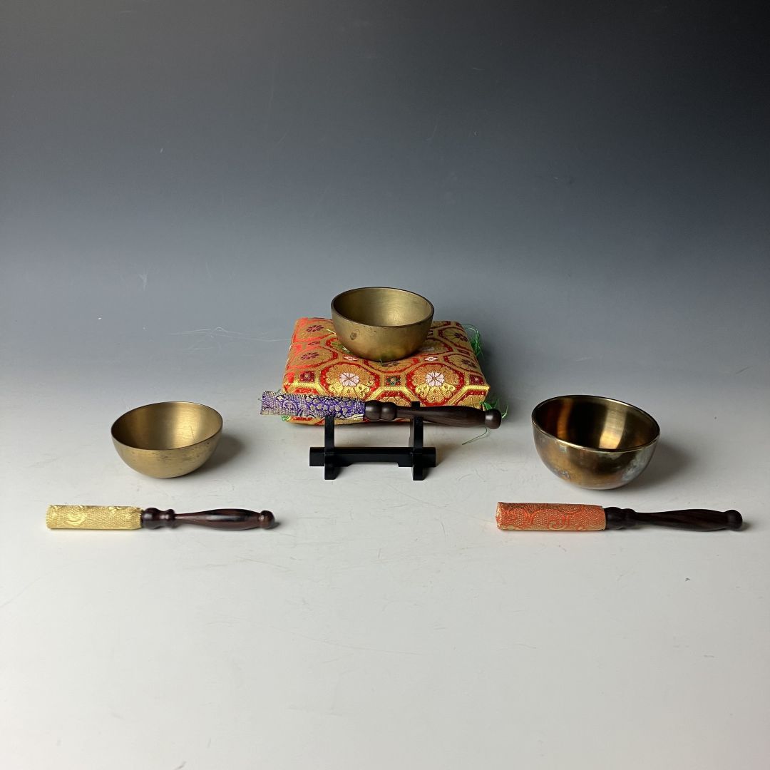 three singing bowls in a grey background