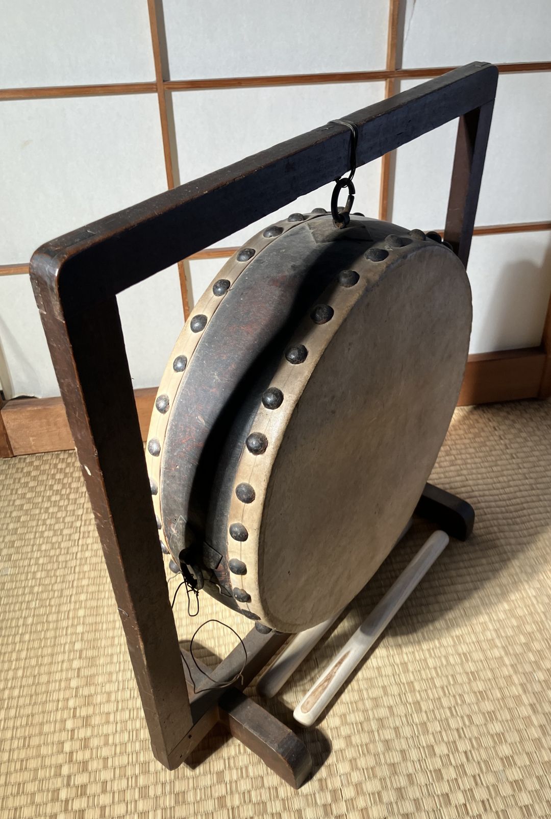 Wooden gong on a stand against a wooden panel background