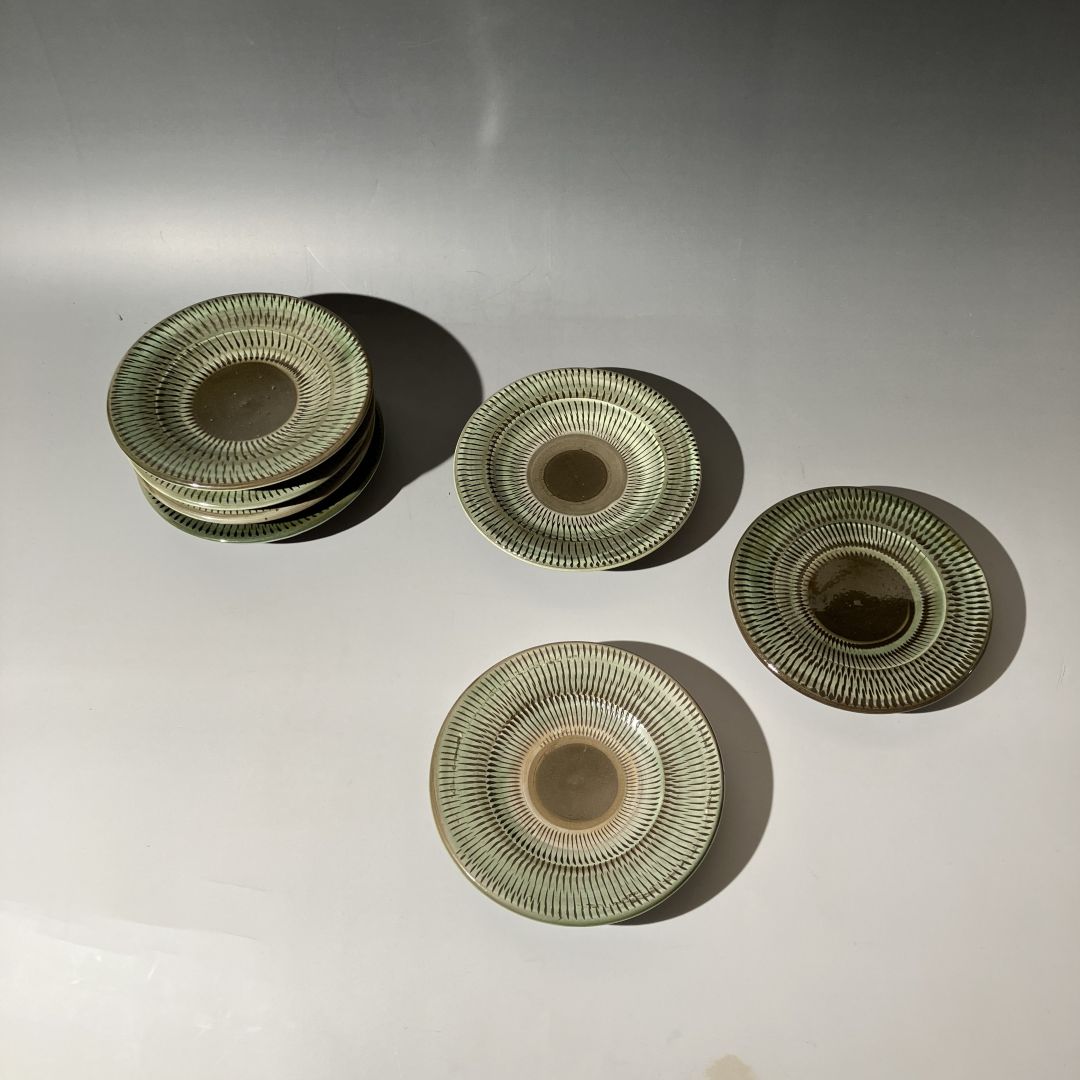 Four ceramic plates with decorative patterns on a white background