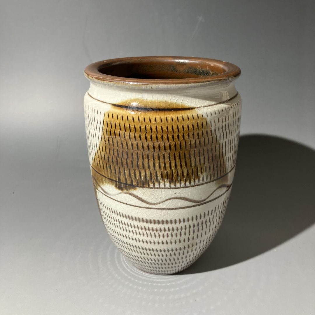 Ceramic vase with brown and beige patterns on a gray background