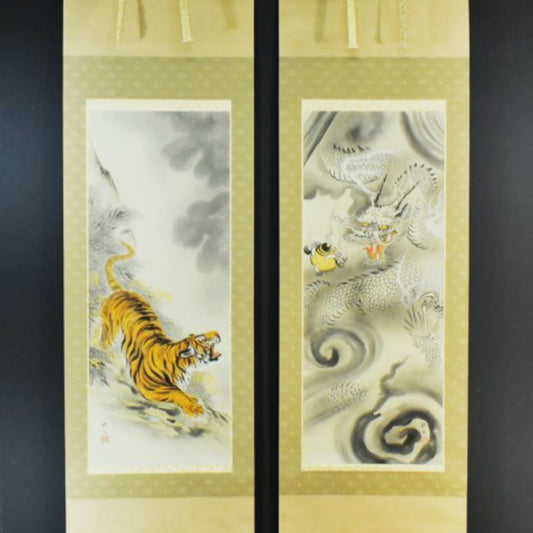 A pair of traditional Japanese hanging scrolls, one featuring a hand-drawn tiger against a backdrop of swirling clouds and the other a majestic dragon, embodying the classic tiger and dragon motif in handmade Japanese art.