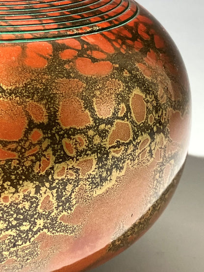 Decorative object with intricate patterns on a red and black background