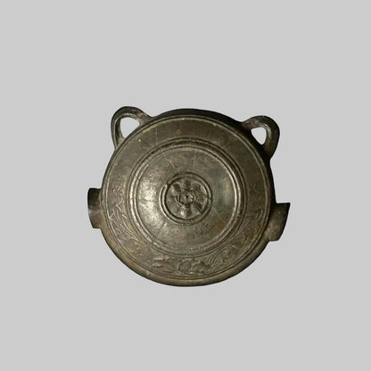 An antique Japanese Waniguchi Gong, made of iron, with a slit in the center and two handles on the side.