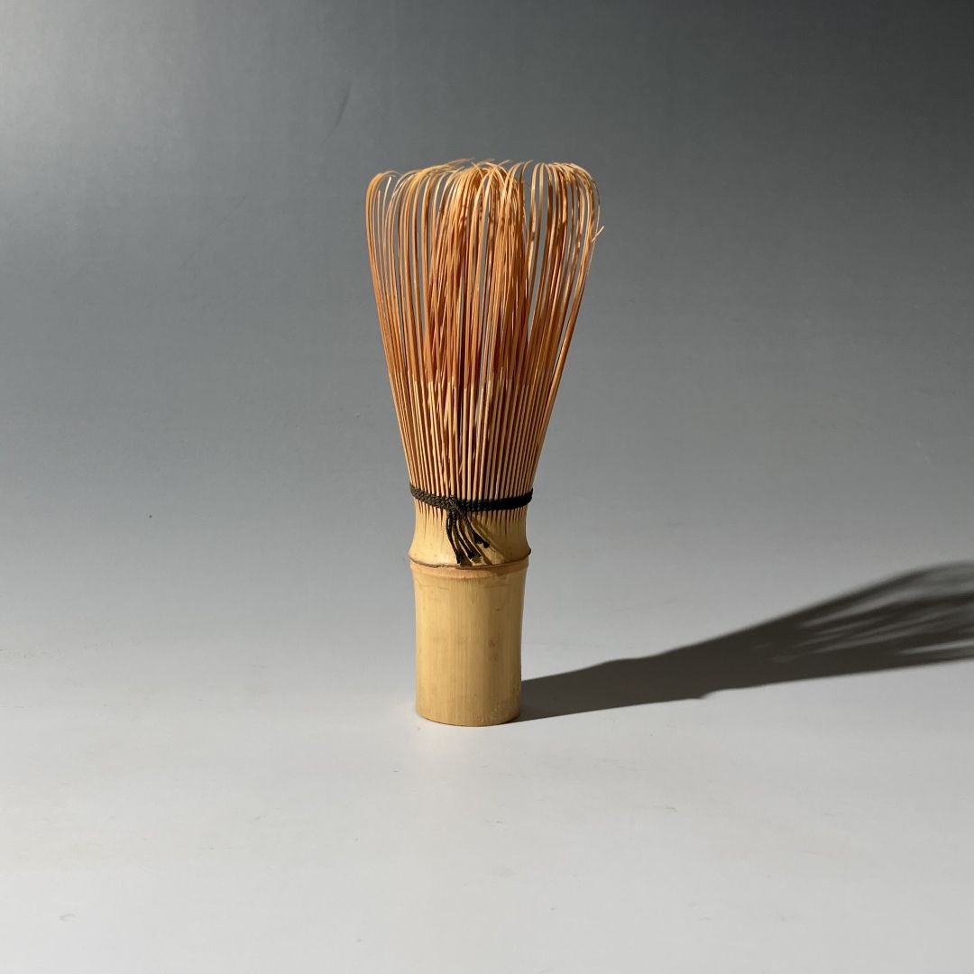 Bamboo whisk with bristles on a gray background