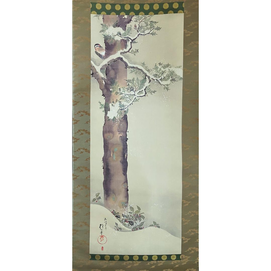 A traditional East Asian scroll painting featuring a plum tree with white blossoms, framed by a decorative border, against a patterned beige backdrop.