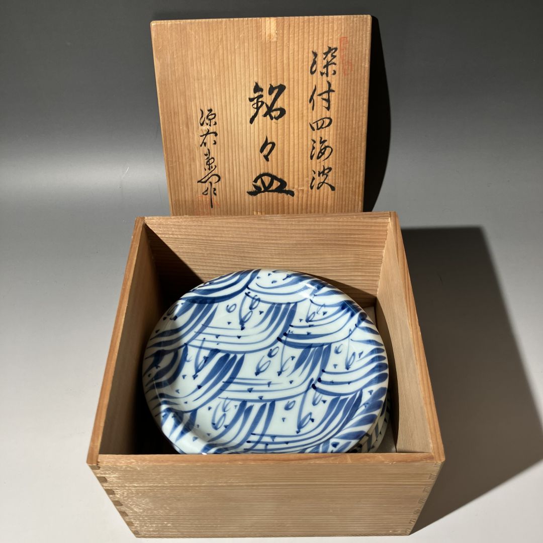 Blue and white ceramic dish in a wooden box with Japanese text