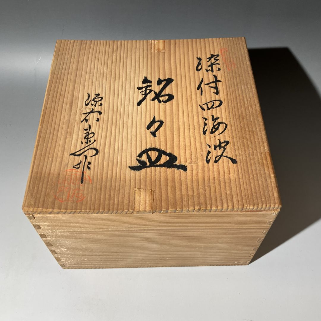 Wooden box with calligraphy on a gray background