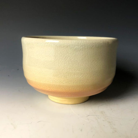 A white cream color chawan tea bowl in a grey background